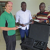 Asheri Stephen (extreme right), Entrepreneur for Rural Access (ERA) from Tanzania receiving the smart projector from Josephine Rodgers, Executive Director of Access Agriculture 